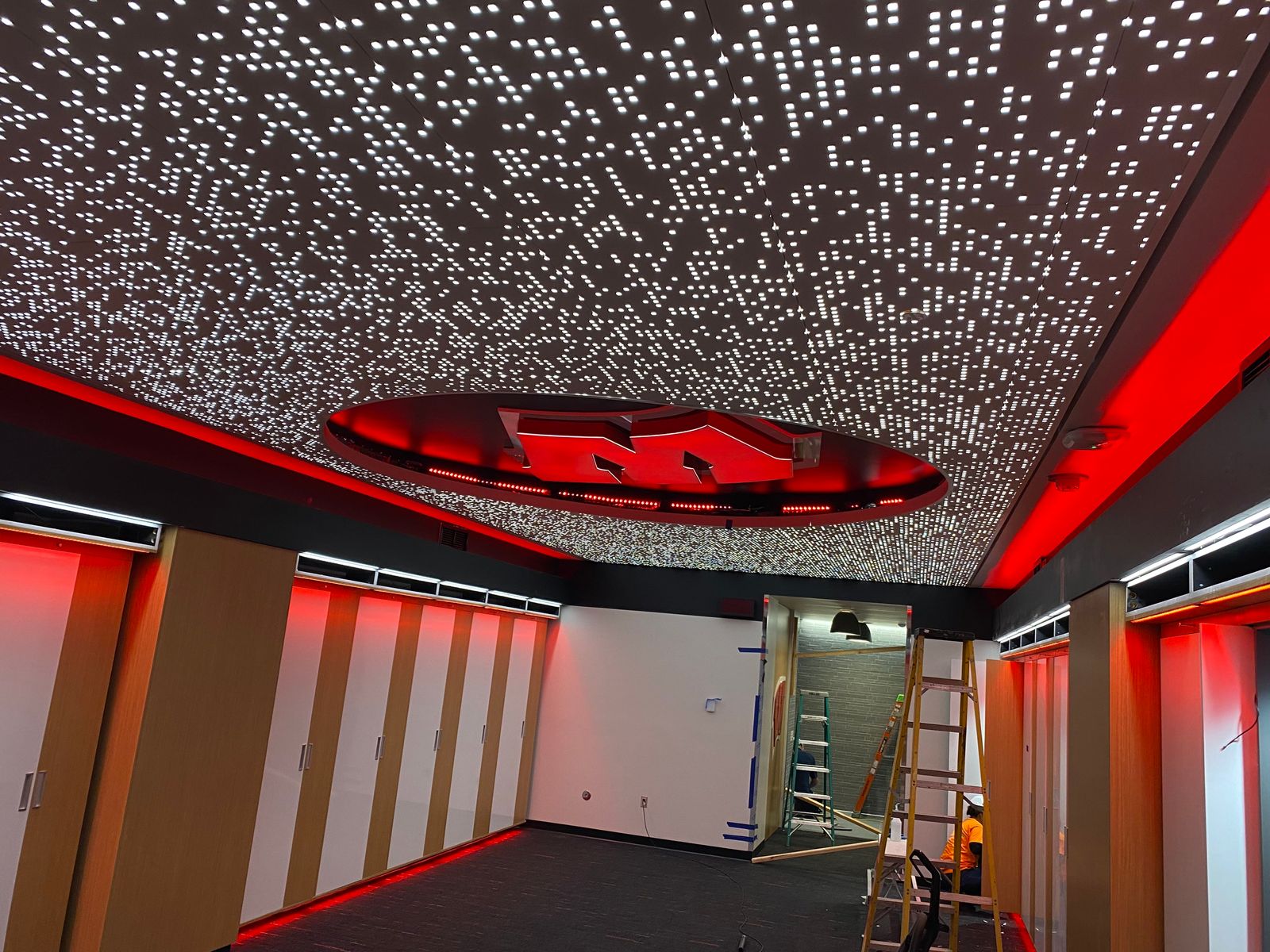 A Badgers locker room with a star-field LED ceiling and backlit W, wired by WIL-Surge